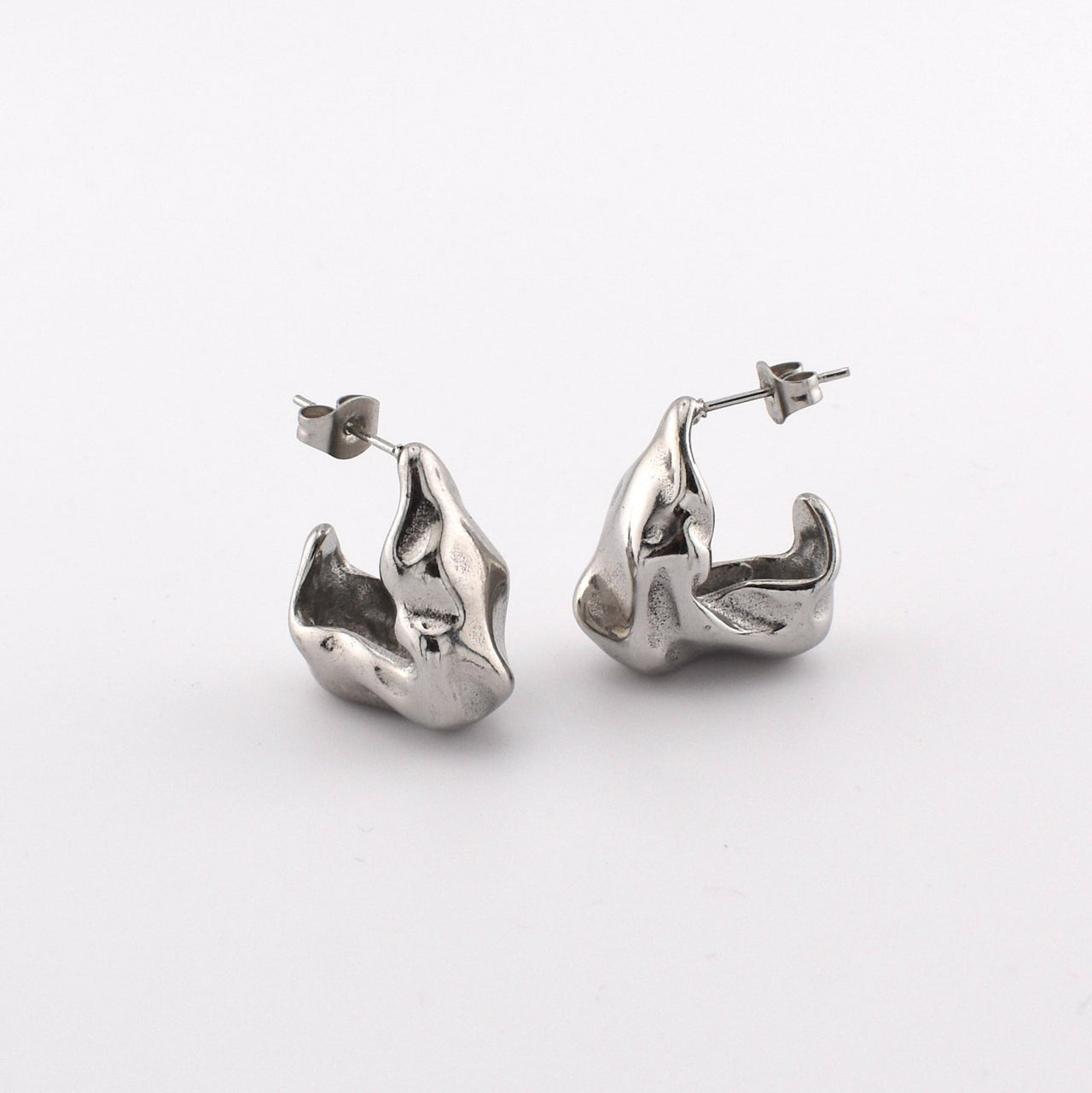 A pair of chunky, hammered, open hoop earrings in gold color with an irregular texture.