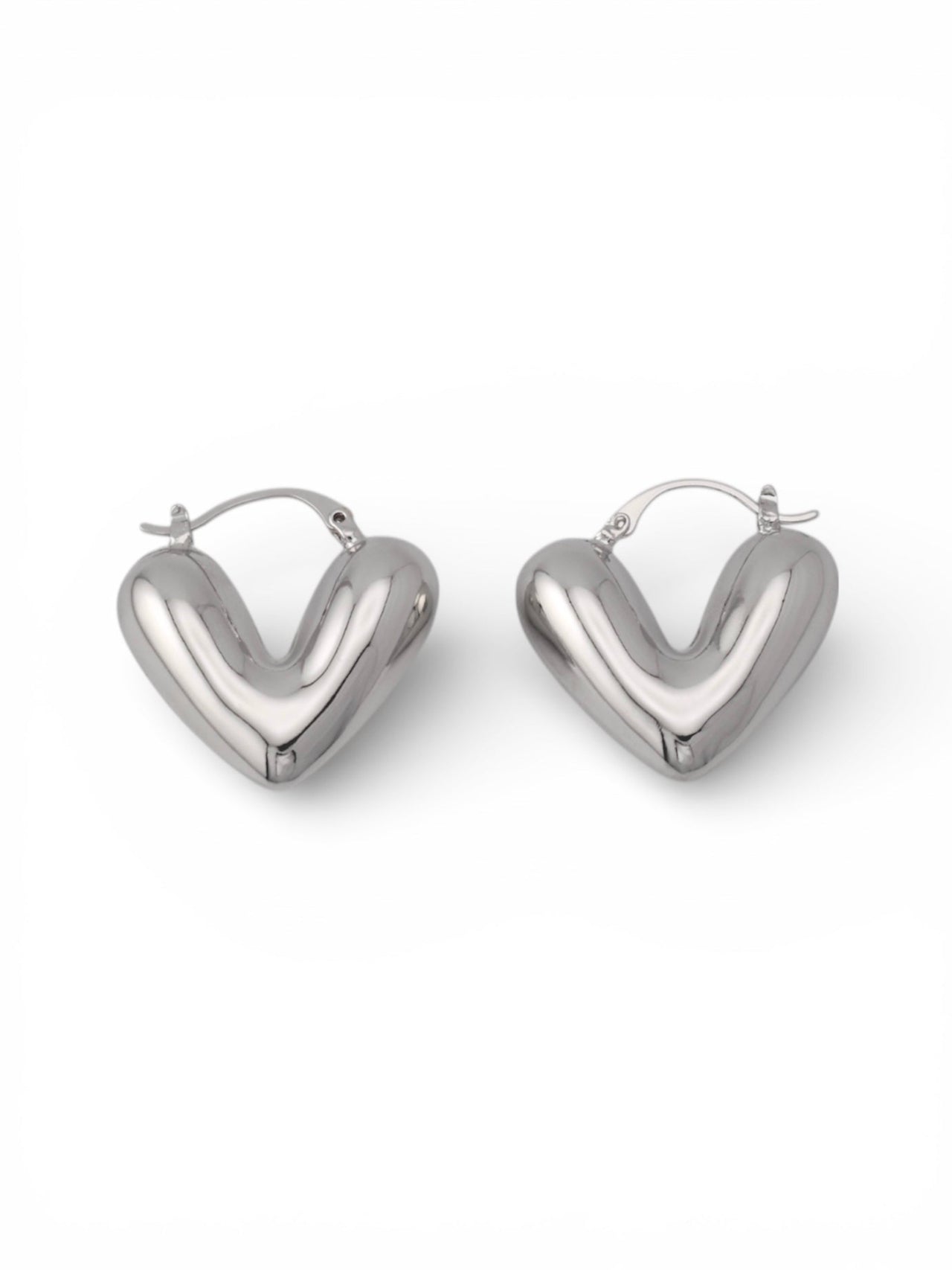 Puffy Silver Heart Earrings with latch back closure against white background